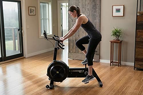 Rider in a Singapore-style HDB room using a Concept2 BikeErg with PM5 console mounted forward