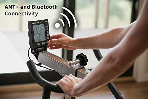 PM5 console close-up showing live wattage and cadence reading during a ride, with Bluetooth and ANT+ wireless icons